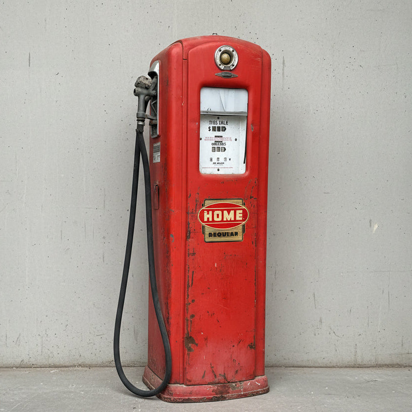 Red vintage gas pump with visible branding in a storage setting